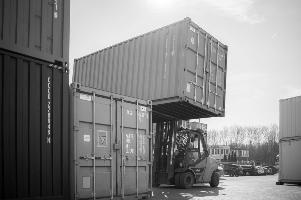 Gabelstapler hebt einen Container auf einen anderen