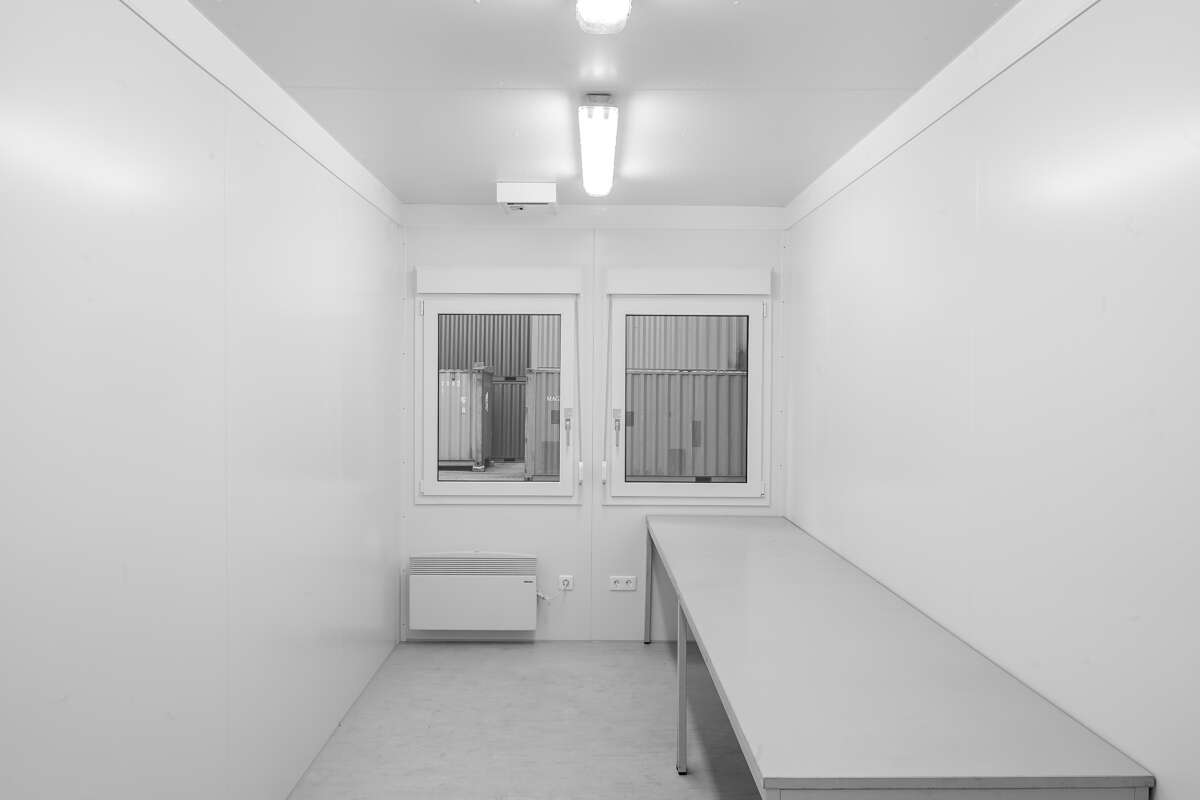 Raumcontainer mit Tisch und Fenstern